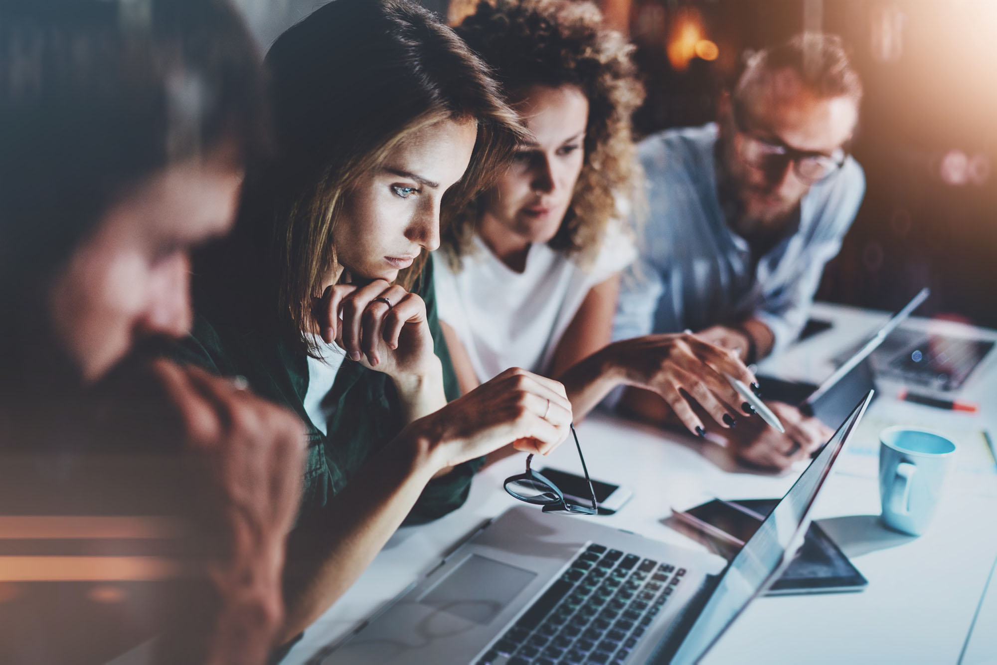 Multiple people on laptops working together on a project